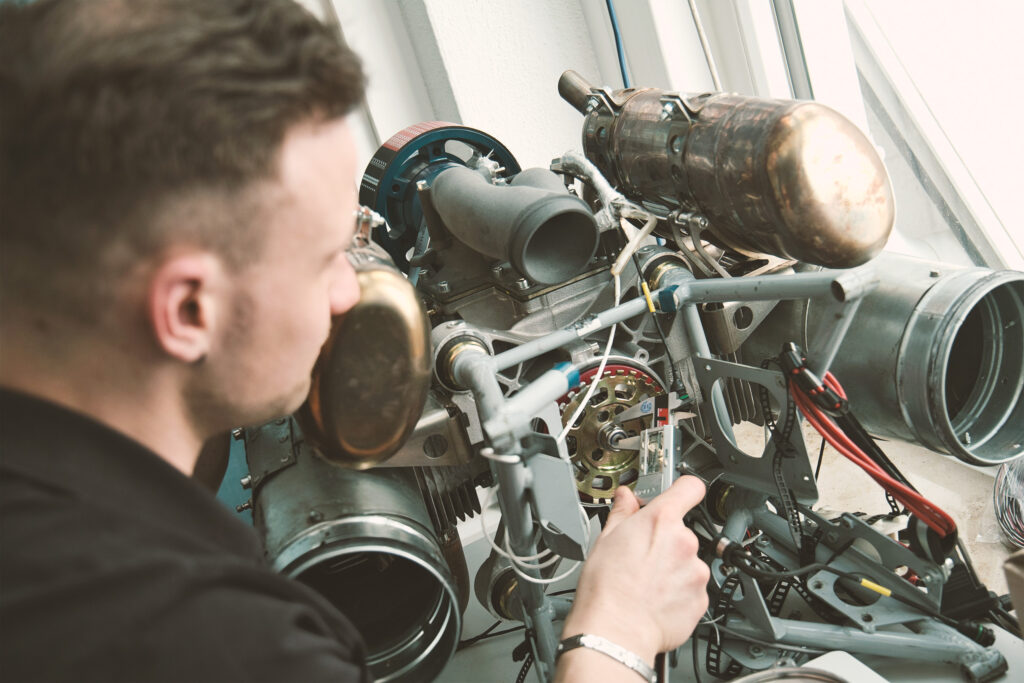 A Hirth technician using a digital caliper to perform high-precision measurements on an aircraft engine component