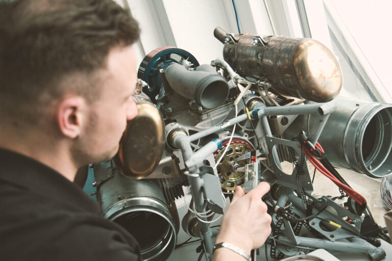 Un technicien de Hirth utilise un pied à coulisse numérique pour effectuer des mesures de haute précision sur un composant de moteur d'avion
